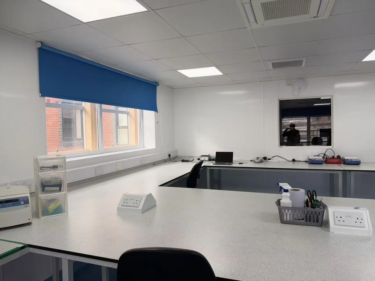 Laboratory interior with fitted benches, sink and blue window blinds