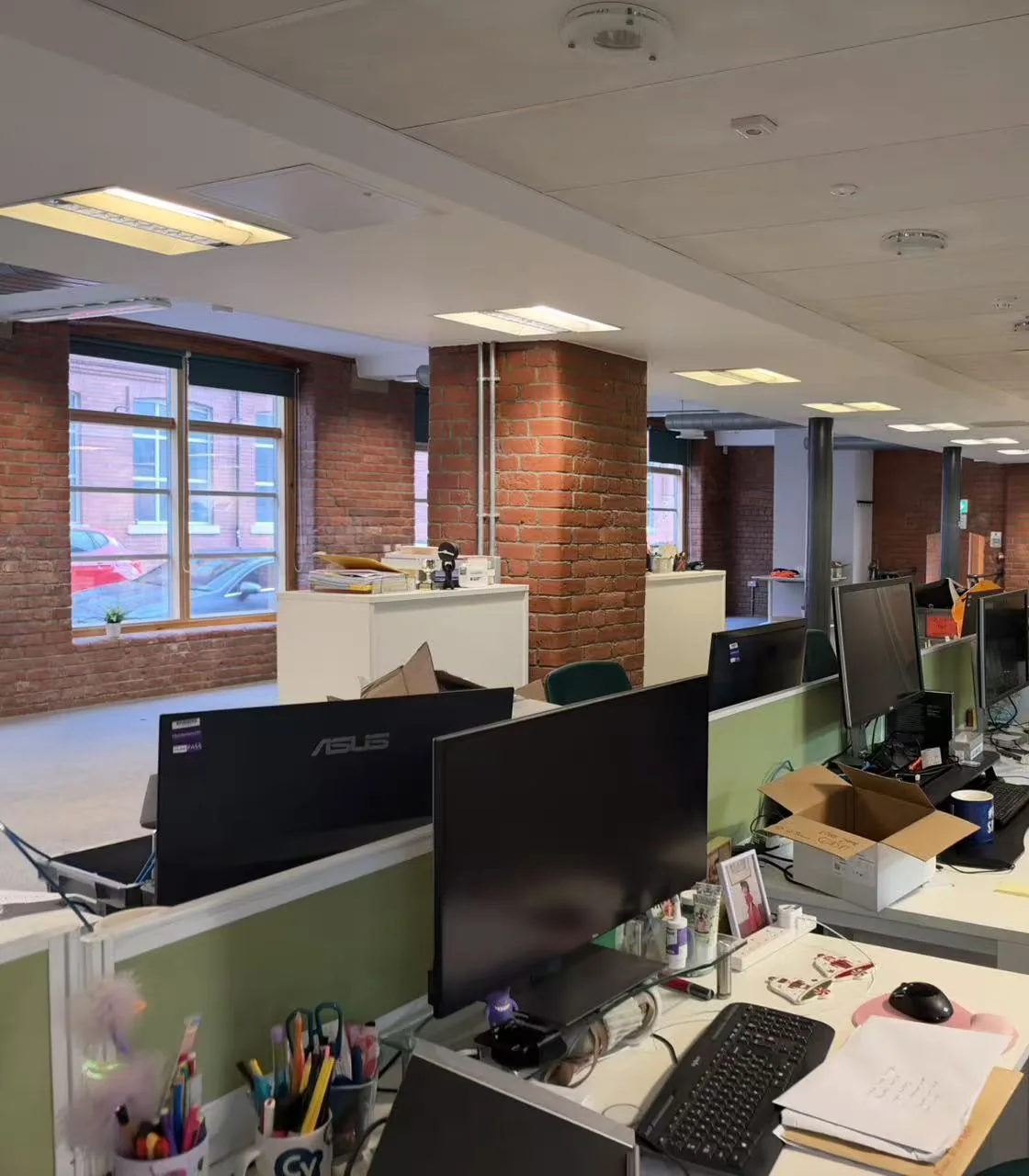 Office accommodation with desks, windows and exposed brickwork