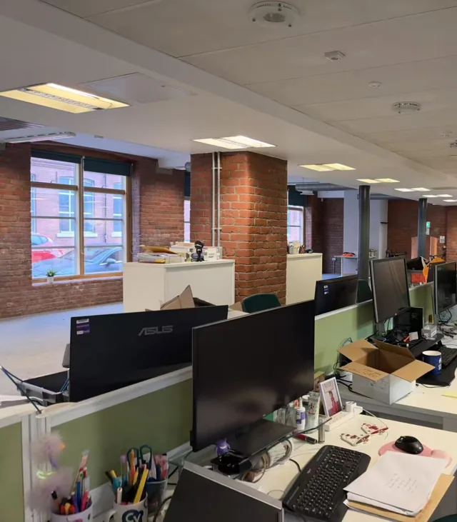 Office desks and exposed brickwork